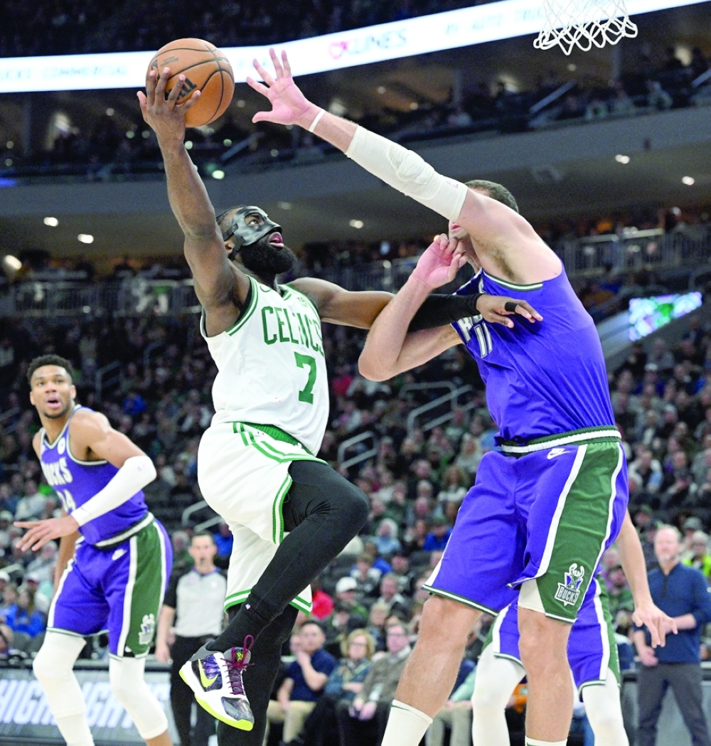 Boston Celtics guard Jaylen Brown (7) drives to the basket against Milwaukee Bucks center Brook Lopez (11) at Fiserv Forum. -- USA TODAY Sports
