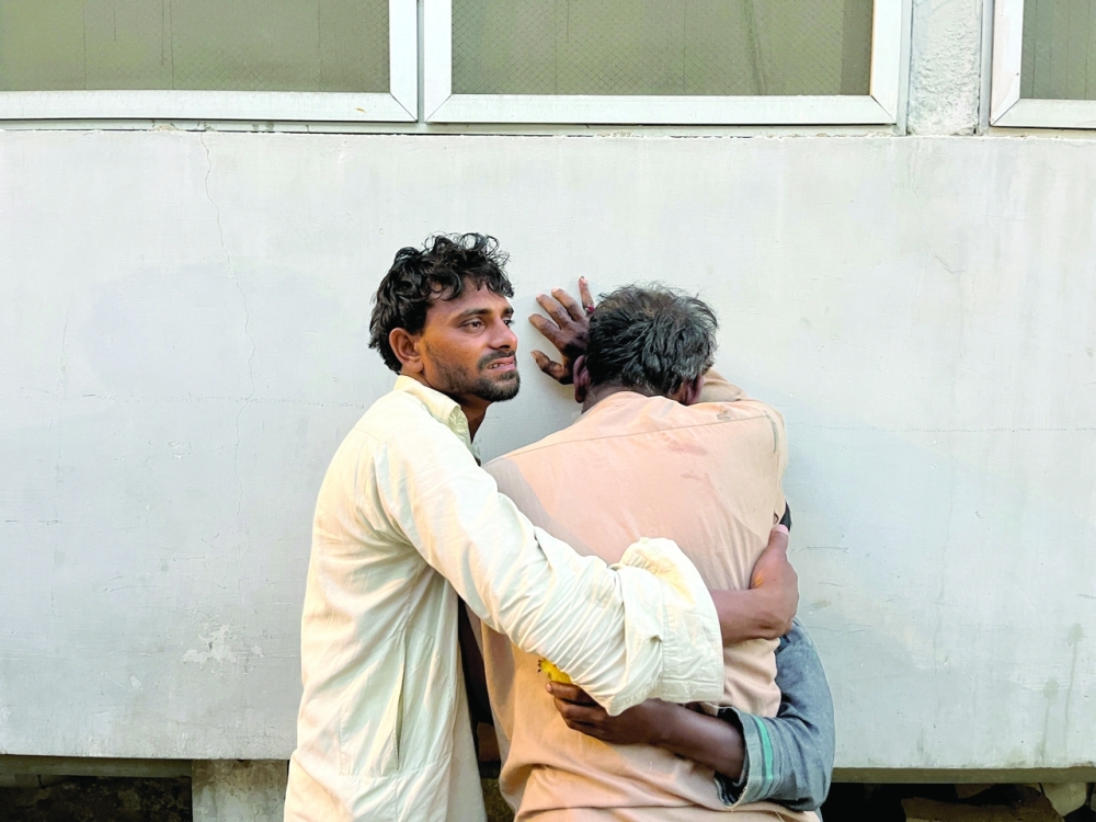 Men mourn the death of relative, who was killed along with others in a stampede at a distribution site for food aid in Karachi. - Reuters

