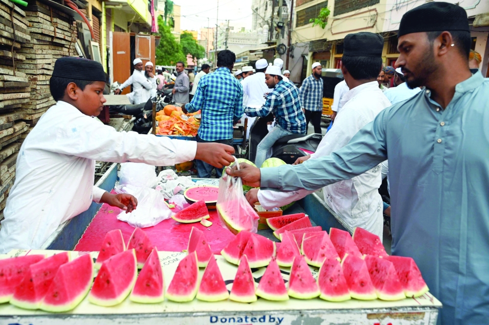A man buys watermelon before breaking the fast during the Muslim holy month of Ramadhan in Hyderabad, India on Friday. — AFP