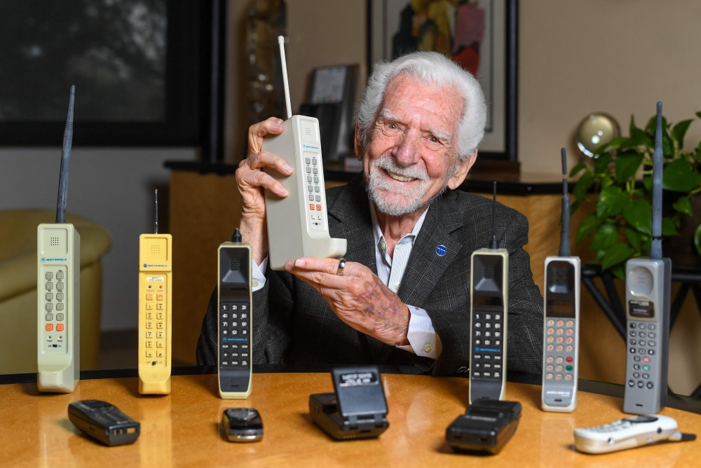 Engineer Martin Cooper holds a contemporary copy of the original cell phone he used to make the first cell phone call on April 3, 1973, in Del Mar, California on March 20, 2023. The problem with mobile phones is that people look at them too much. At least, that's according to the man who invented them 50 years ago. Martin Cooper, an American engineer dubbed the "Father of the cell phone," says the neat little device we all have in our pockets has almost boundless potential and could one day even help conquer disease. But right now, we can be a little obssessed. (Photo by VALERIE MACON / AFP)


