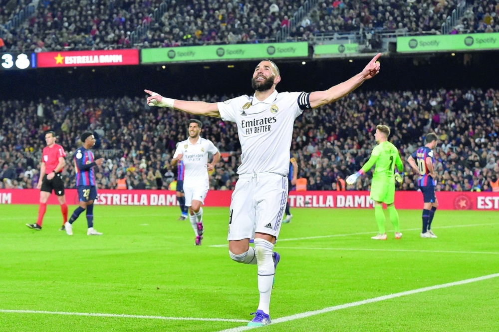 TOPSHOT - Real Madrid's French forward Karim Benzema celebrates after scoring his team's fourth goal during the Copa del Rey (King's Cup) semi-final second leg football match between FC Barcelona and Real Madrid CF at the Camp Nou stadium in Barcelona on April 5, 2023. (Photo by Pau BARRENA / AFP)

