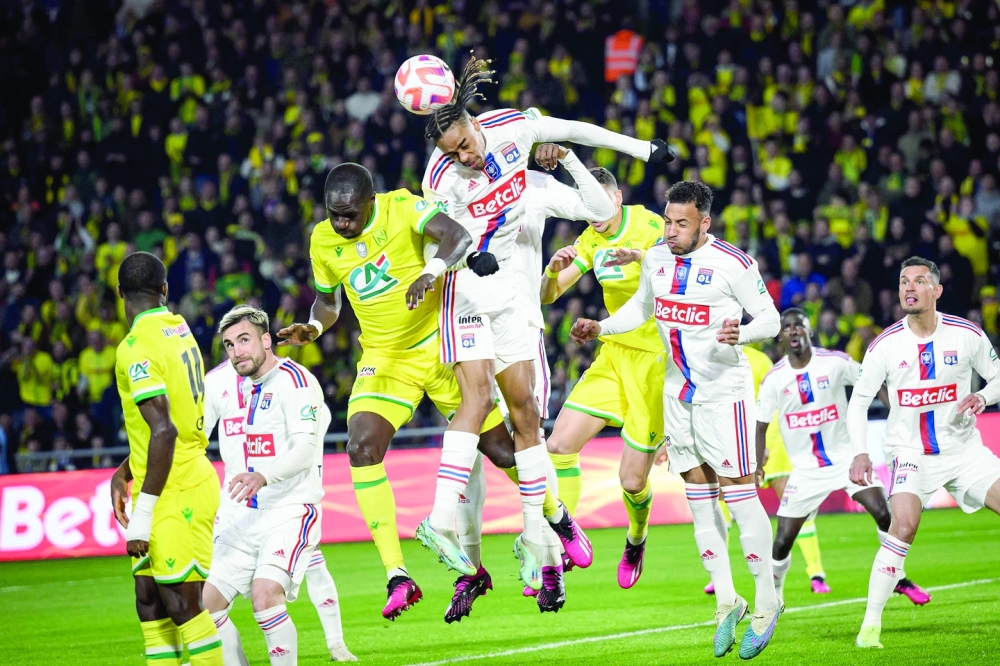 TOPSHOT - Lyon's French forward Bradley Barcola (C) jumps to intercept the ball during the French Cup semifinal football match between FC Nantes and Lyon at the La Beaujoire Stadium in Nantes, western France on April 5, 2023.  (Photo by LOIC VENANCE / AFP)