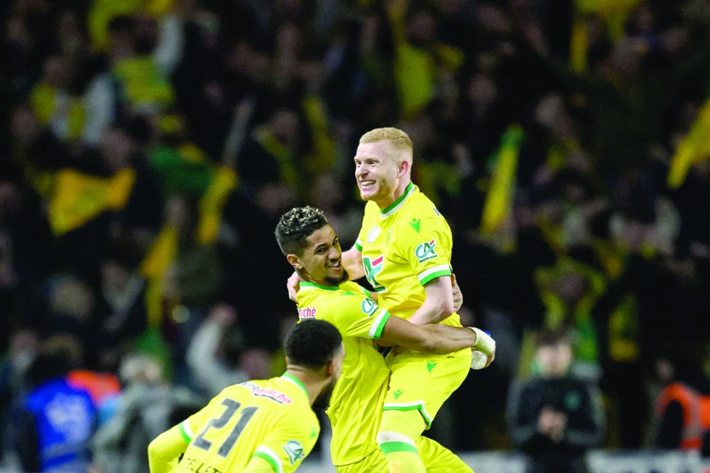 Nantes' French midfielder Florent Mollet (R) and Nantes' French midfielder Ludovic Blas (C) celebrate their victory after winning the French Cup semifinal football match between FC Nantes and Lyon at the La Beaujoire Stadium in Nantes, western France on April 5, 2023.  (Photo by LOIC VENANCE / AFP)