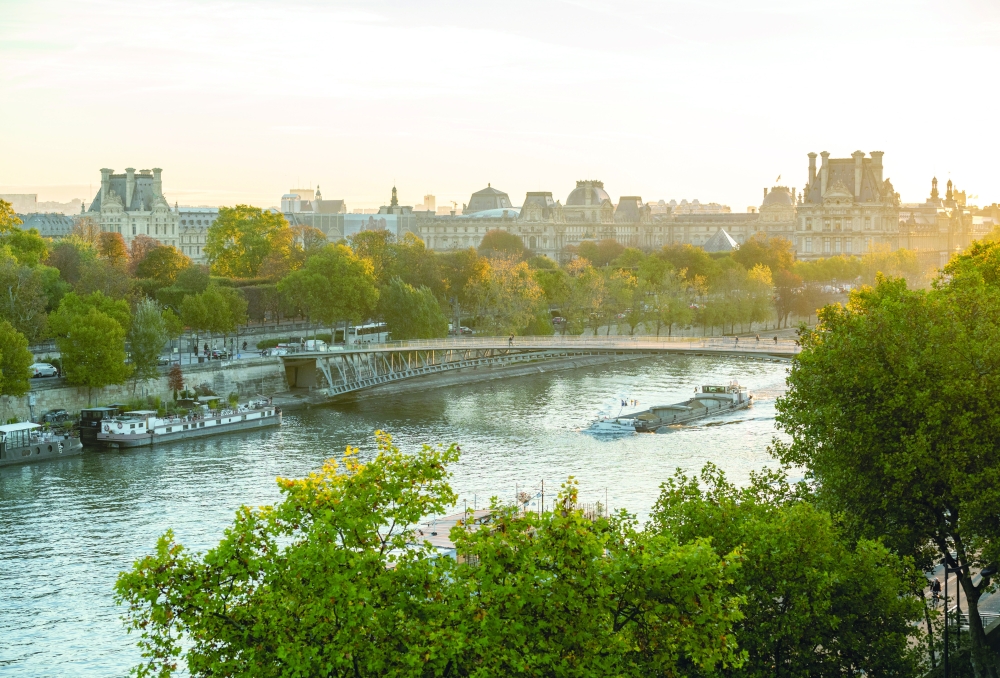 A barge traverses the Seine near the Louvre at sunrise in Paris, Oct. 26, 2022. (James Hill/The New York Times) 
