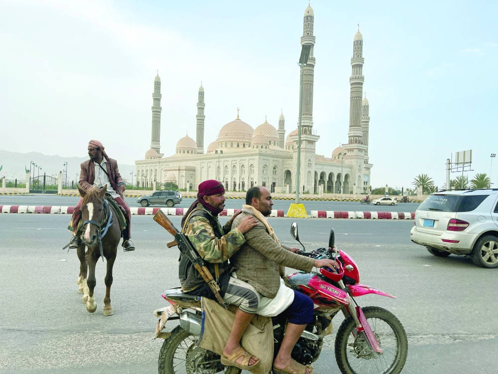 People ride on a motorbike as delegations hold talks with Ansar Allah in Sanaa. -- Reuters