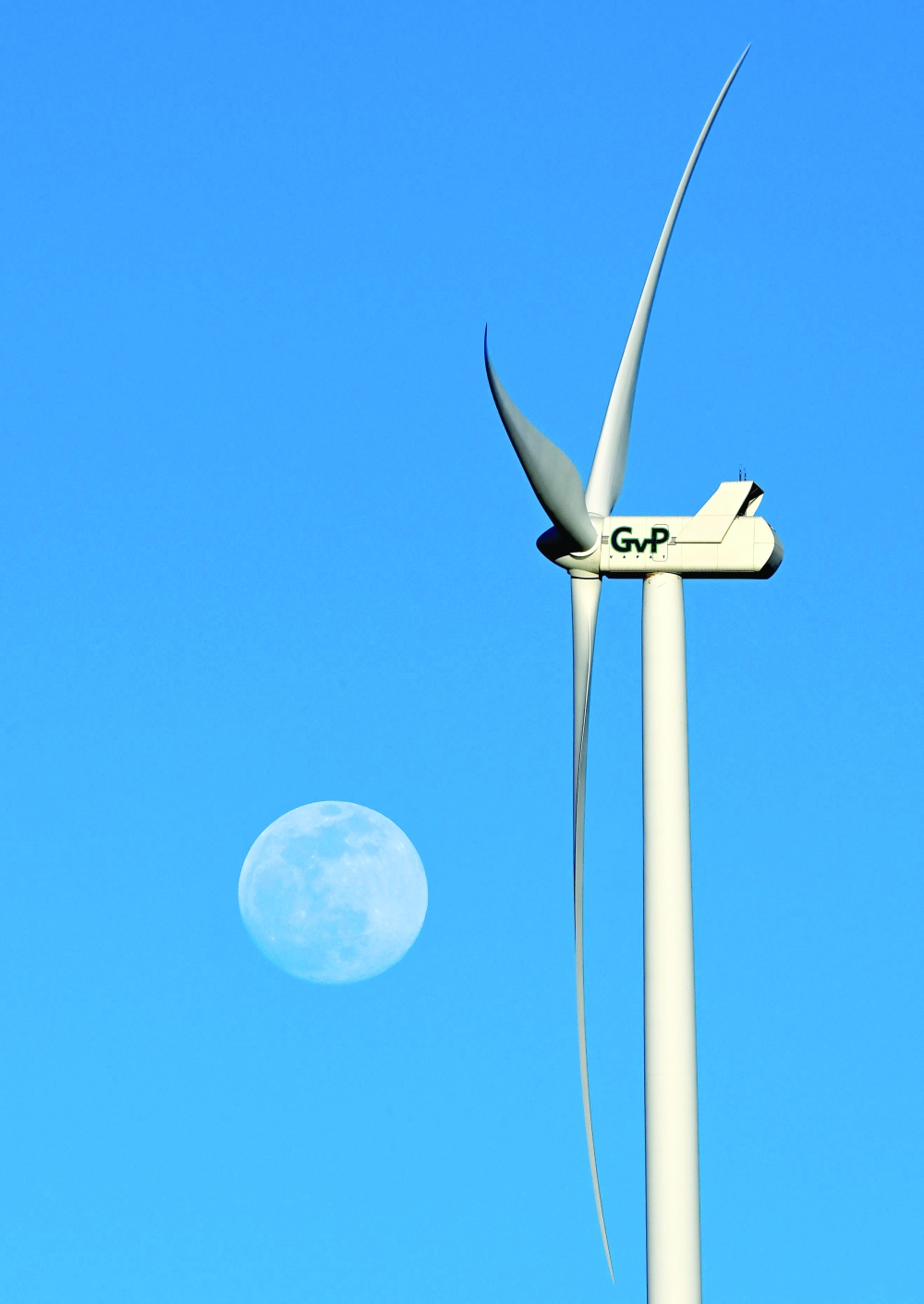 A wind turbine is pictured with the Moon in the background in Coculina, Burgos province. - AFP
