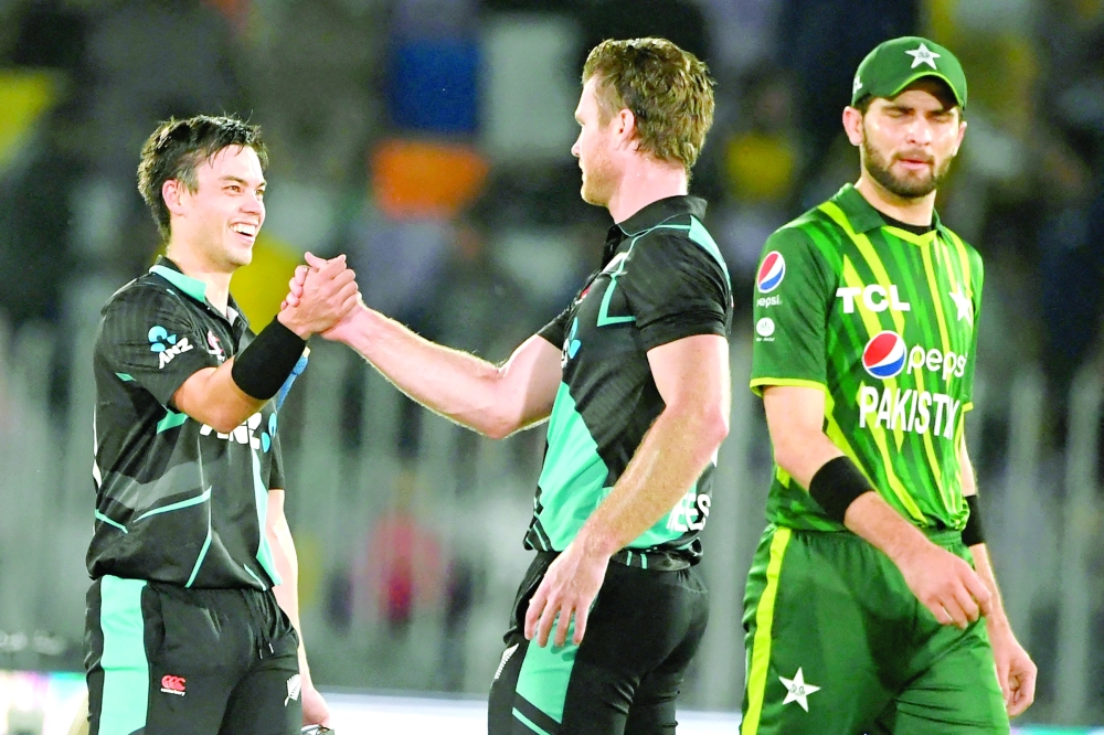New Zealand's Mark Chapman (L) celebrates with teammate Jimmy Neesham (C) after winning the fifth and final Twenty20 international cricket match between Pakistan and New Zealand at the Rawalpindi Cricket Stadium in Rawalpindi, on April 25, 2023.
  (Photo by Aamir QURESHI / AFP)

