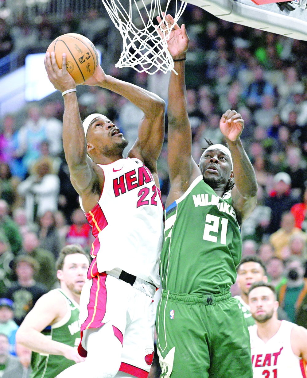 Miami Heat forward Jimmy Butler (22) shoots the ball against Milwaukee Bucks guard Jrue Holiday (21) during game five of the 2023 NBA play-offs at Fiserv Forum. Mandatory Credit: Michael McLoone-USA TODAY Sports