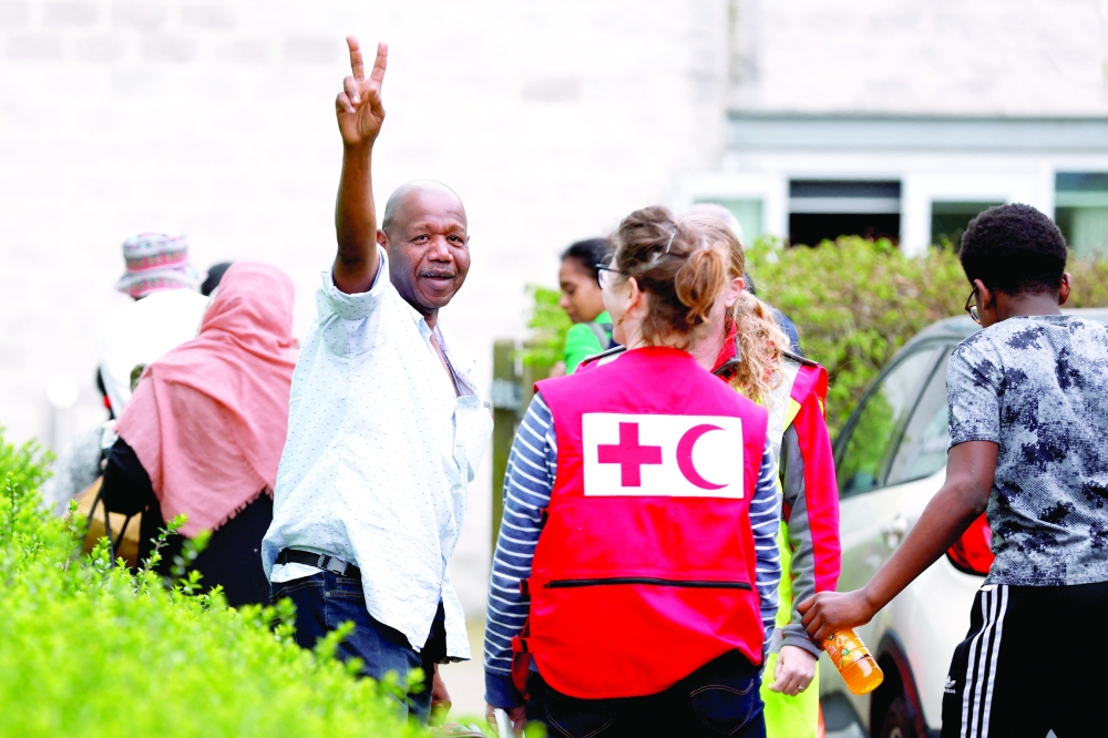 A passenger, believed to be a British national, gestures after arriving  at London Stansted Airport, following evacuation from Sudan, in Stansted, Britain. -- Reuters