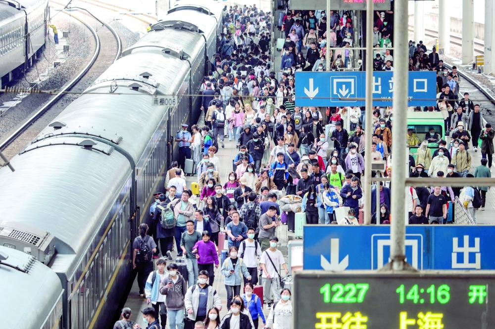 Passengers prepare to board their train at the Nanjing Train Station, in China's eastern Jiangsu province ahead of the Labour Day holiday which starts on April 29. - AFP

