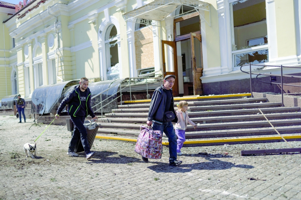 People run near a train station hit by a Russian military strike, amid Russia's attack on Ukraine, in Kherson. — Reuters