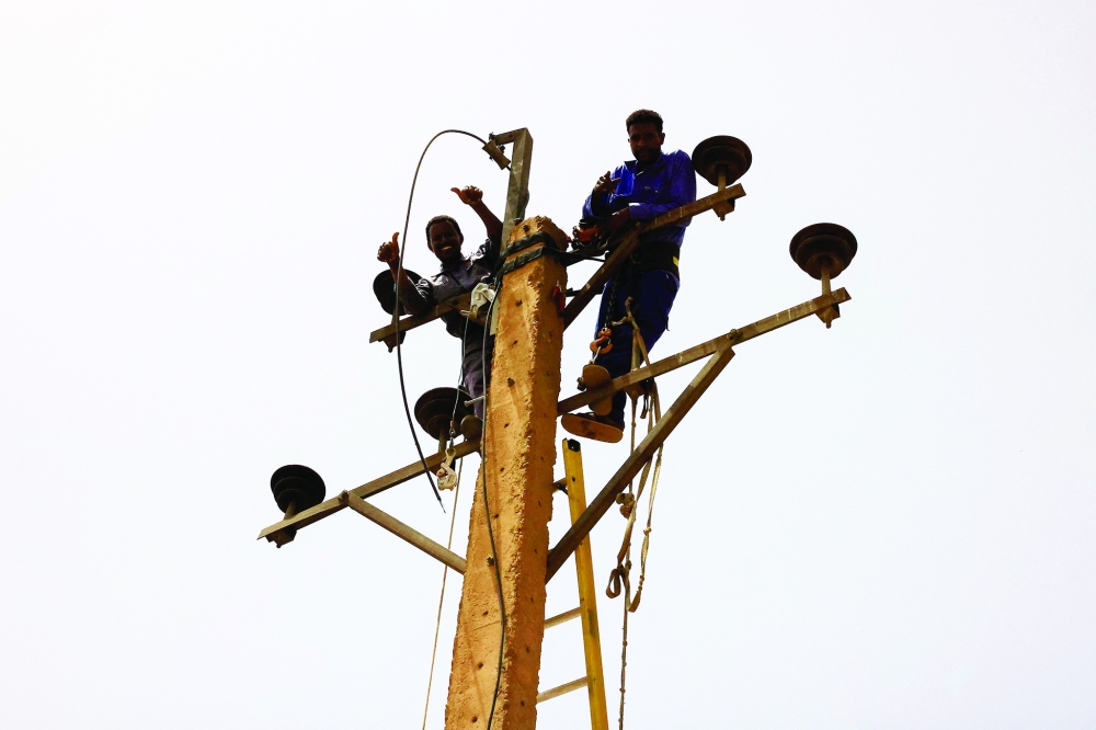 Electricity workers rehabilitate the power lines at the central market during clashes between the paramilitary Rapid Support Forces and the army in Khartoum North. - REUTERS