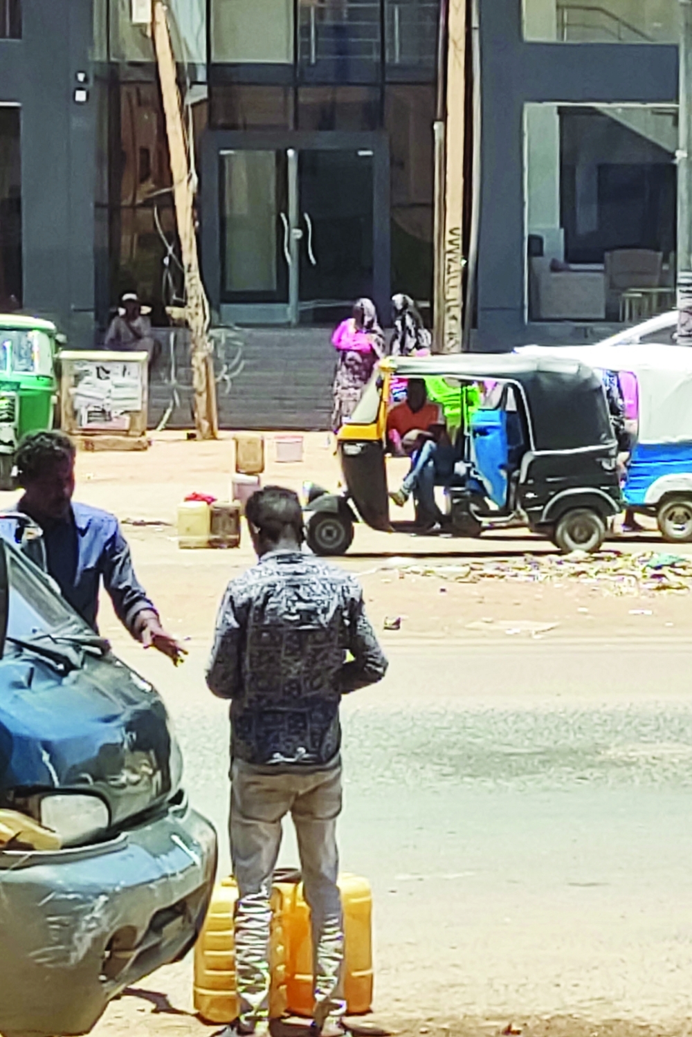 Men stand by fuel containers on sale in a street in southern Khartoum, on May 4, 2023. Gunfire and explosions gripped Khartoum for a 20th straight day leaving the latest ceasefire effort in tatters, a day after UN chief Antonio Guterres acknowledged the international community had "failed" Sudan. AFP