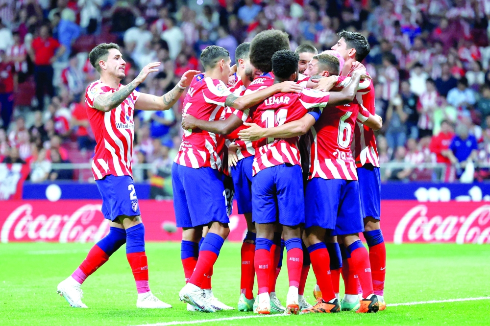 TOPSHOT - Atletico Madrid's players celebrate their fourth goal scored by Belgian midfielder Yannick Ferreira-Carrasco during the Spanish league football match between Club Atletico de Madrid and Cadiz CF at the Wanda Metropolitano stadium in Madrid on May 3, 2023. (Photo by Pierre-Philippe MARCOU / AFP)

