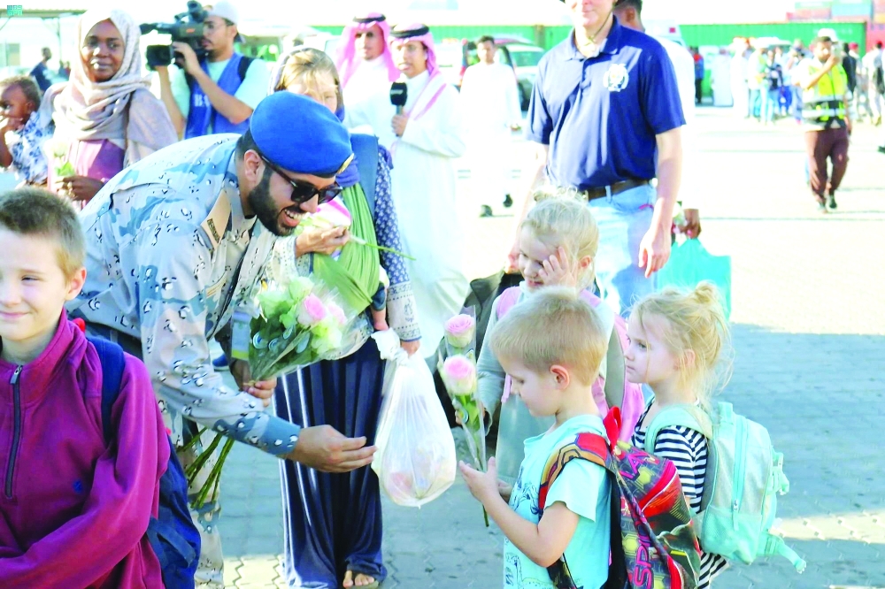 A Saudi Royal Navy official gives flowers welcoming US citizens who disembarked from the US Navy fast transport ship, the USNS Brunswick, which arrived with US and other nationalities evacuated to Saudi Arabia from Sudan, to escape the conflicts, at the Jeddah Sea Port, Saudi Arabia. — Reuters