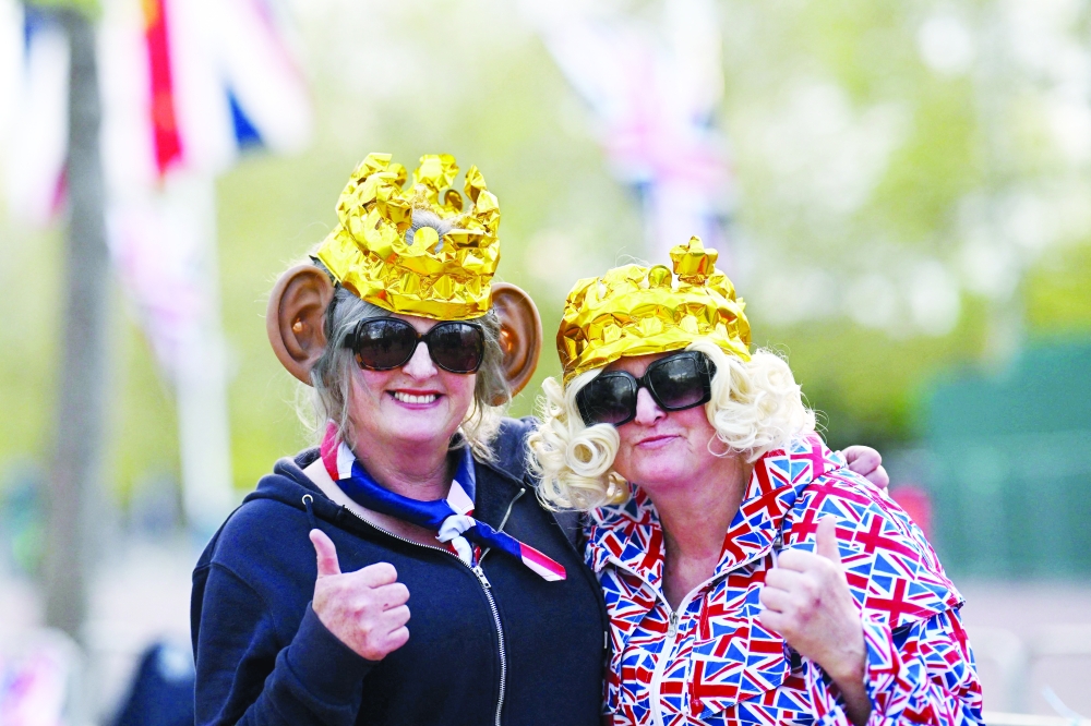 Royal fans wearing crowns and false ears pose for a picture, near to Buckingham Palace in central London ahead of the coronation weekend. 
— AFP
