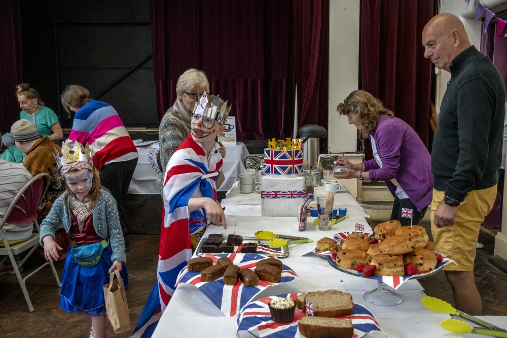 Children at a tea and cake stall during a King Charles lll coronation celebration in Shirehampton, a part of northwestern Bristol, England, on Saturday, April 29, 2023. (Andrew Testa/The New York Times)