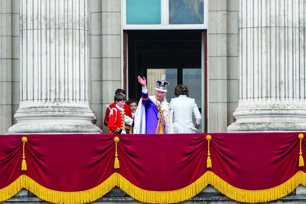 King Charles returns to the balcony at Buckingham Palace to wave once more to his subjects after his coronation in London.