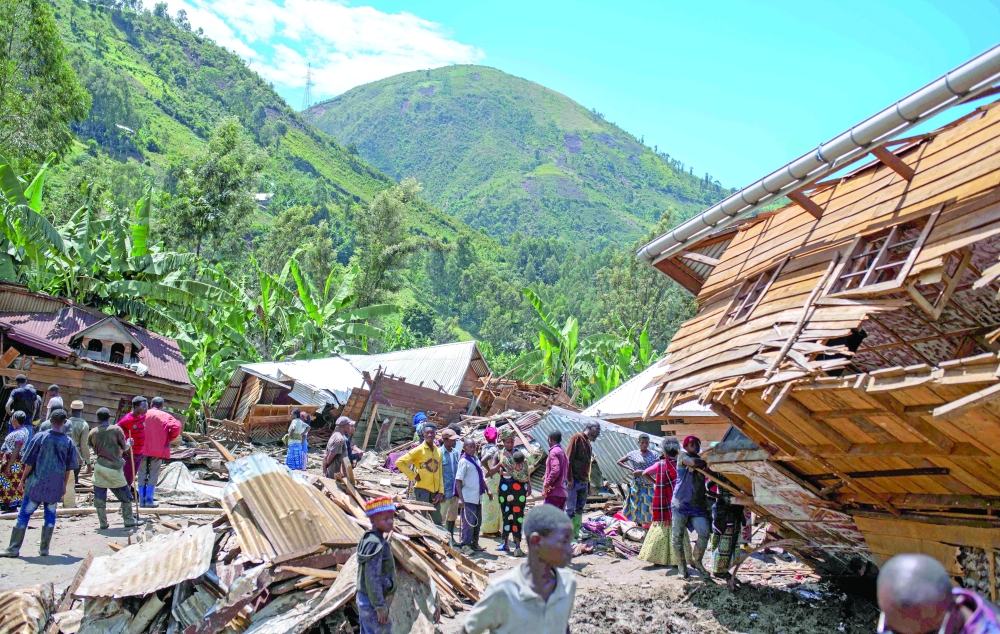 Congolese civilians gather after the death of their family members following rains that destroyed building in the village of Nyamukubi. — Reuters 