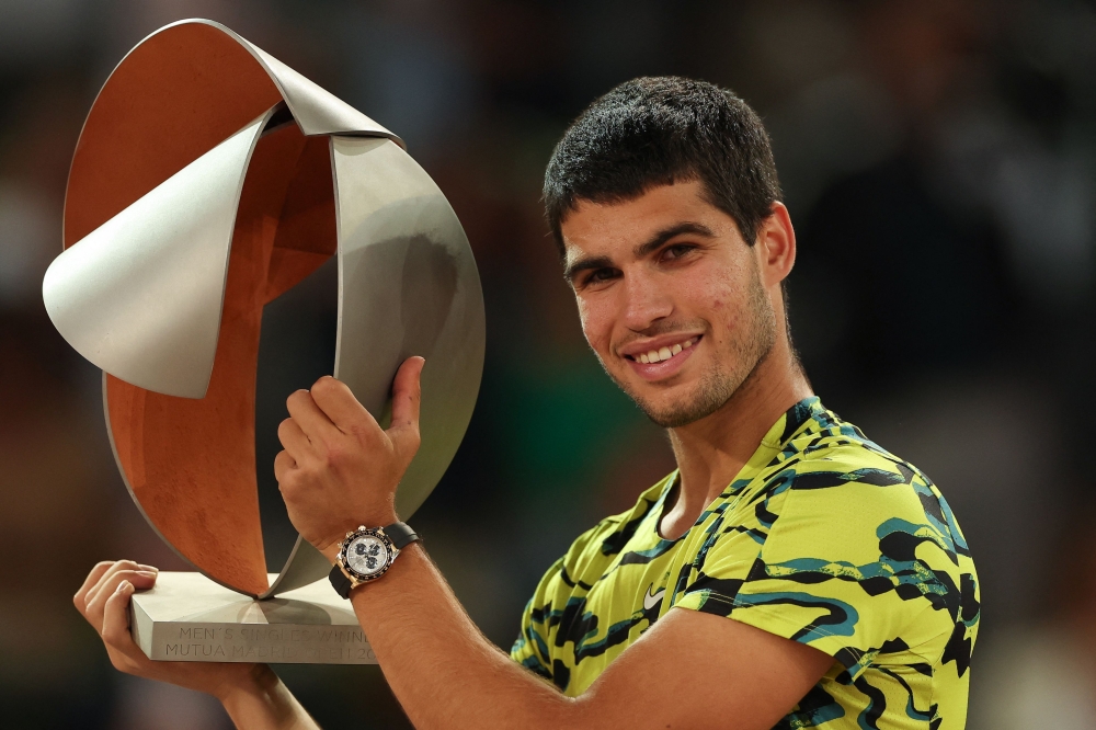 Spain's Carlos Alcaraz poses for pictures with the trophy after winning the 2023 ATP Tour Madrid Open tennis tournament singles final match against Germany's Jan-Lennard Struff at Caja Magica in Madrid on May 7, 2023. (Photo by Pierre-Philippe MARCOU / AFP)


