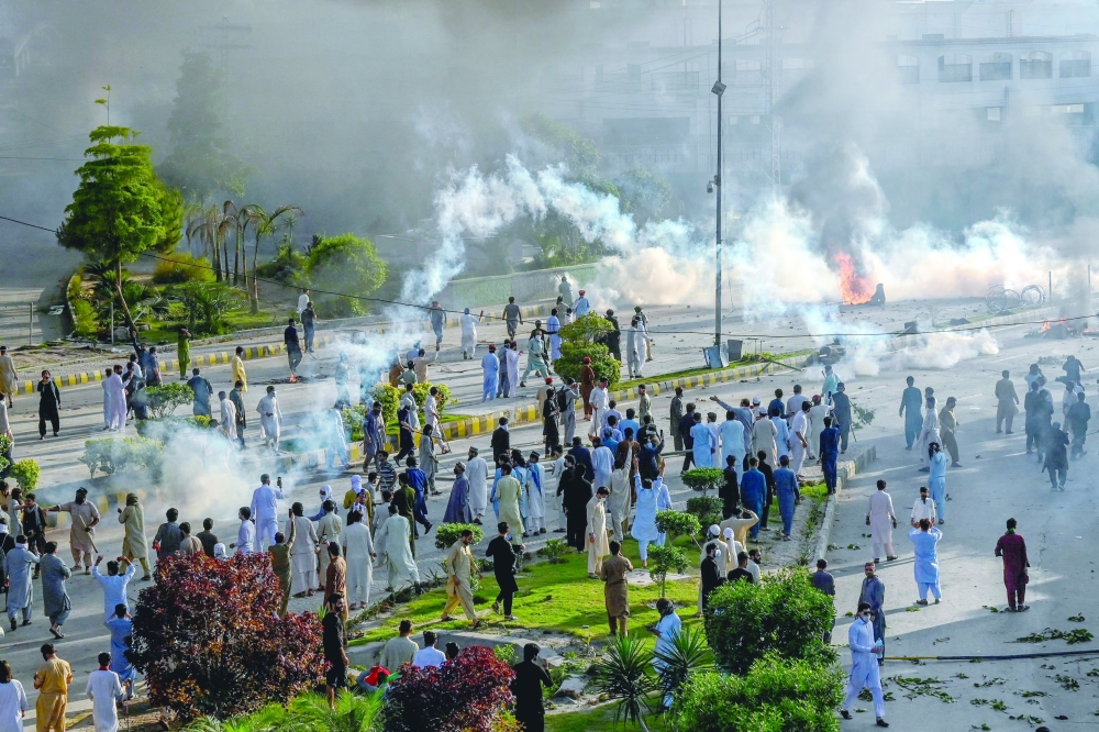 Police fire teargas shells towards activists and supporters of former PM Imran during a protest against the arrest in Peshawar. — AFP