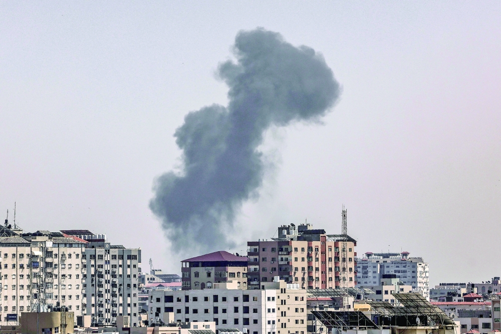 A plume of smoke rises above buildings in Gaza City during an israeli air strike on Thursday, on the third day of the worst escalation of violence in months that has killed 25 people in the blockaded Palestinian enclave. Air strikes by the Israeli army since May 9 have killed fighters as well as civilians, including several children, said officials in the crowded coastal territory. - AFP