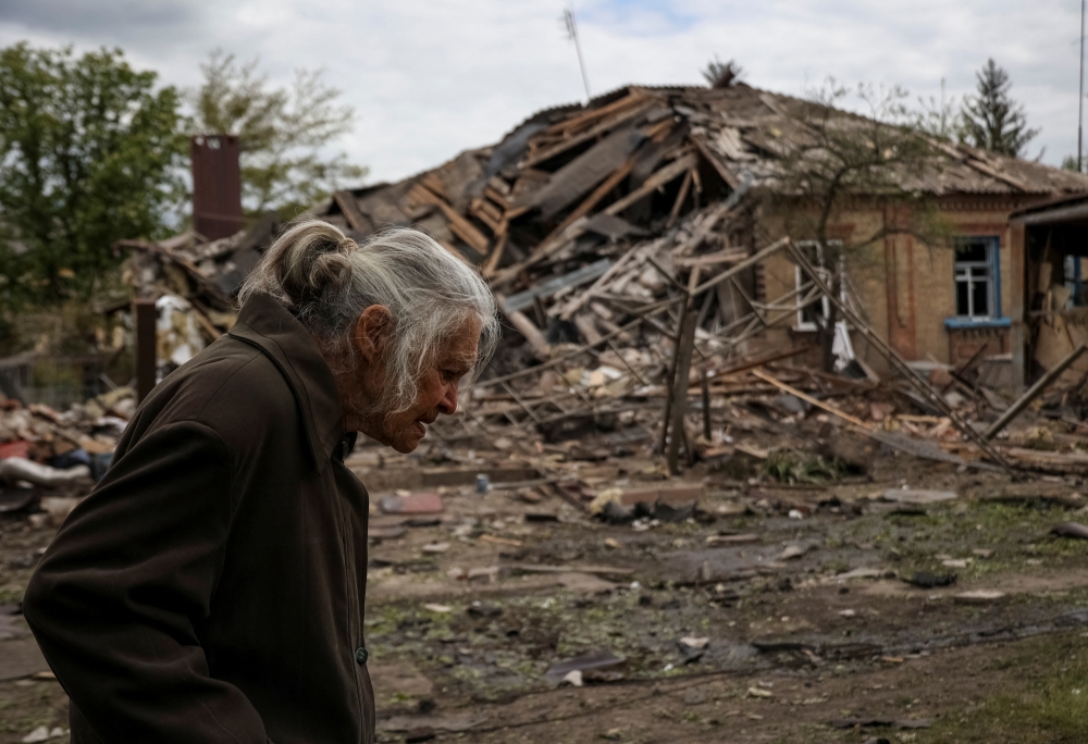 A local resident passes by a house hit by a Russian military strike, amid Russia's attack on Ukraine, in the town of Sloviansk, Donetsk region. - Reuters

