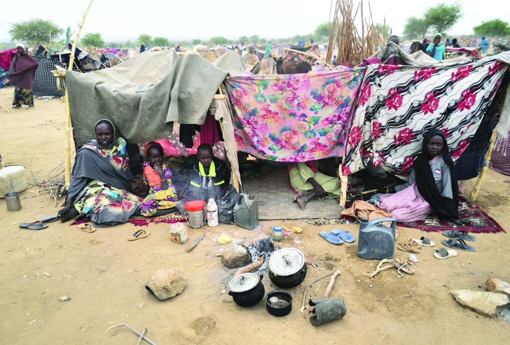 Sudanese refugees who have fled the violence in Sudan's Darfur region, sit at their makeshift shelters near the border between Sudan and Chad in Koufroun, Chad. - Reuters