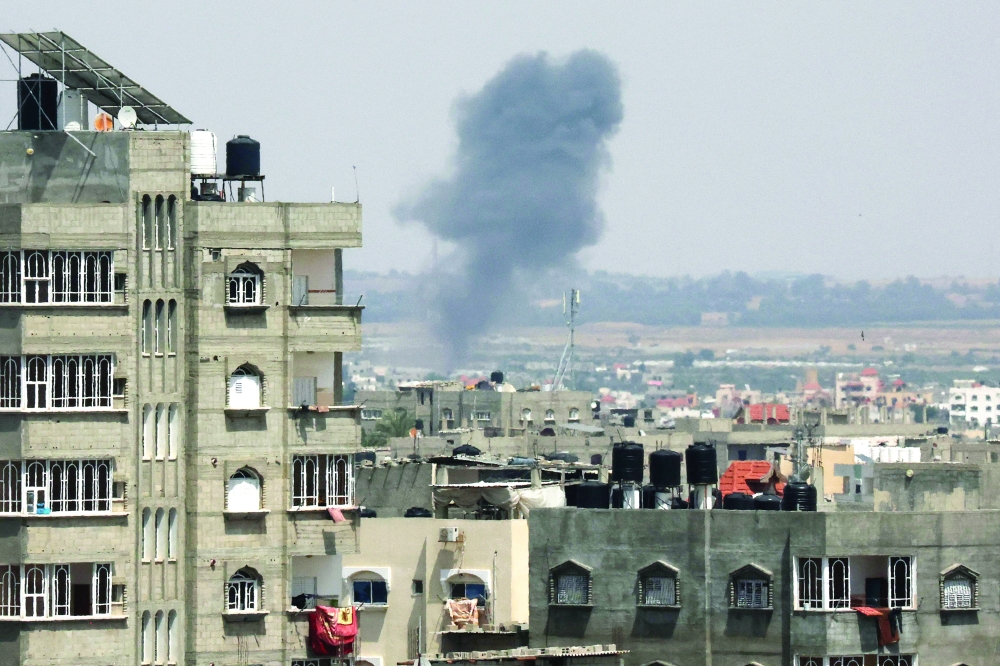 Smoke rises above buildings in Khan Yunis, in the southern Gaza Strip, following an Israeli military strike on Friday. Israel and Gaza fighters traded heavy fire as hopes faded of securing a truce to end days of fighting that have killed dozens, all but one of them Palestinian. - AFP