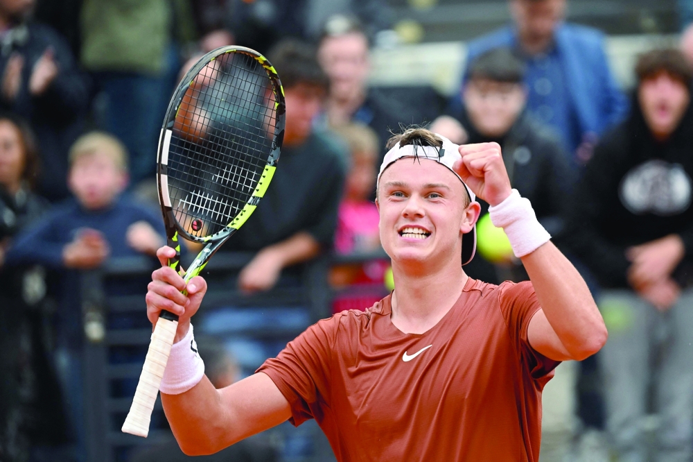 Denmark's Holger Rune celebrates after defeating Serbia's Novak Djokovic in their quarterfinals match of the Men's ATP Rome Open tennis tournament at Foro Italico in Rome on May 17, 2023.  (Photo by Filippo MONTEFORTE / AFP)

