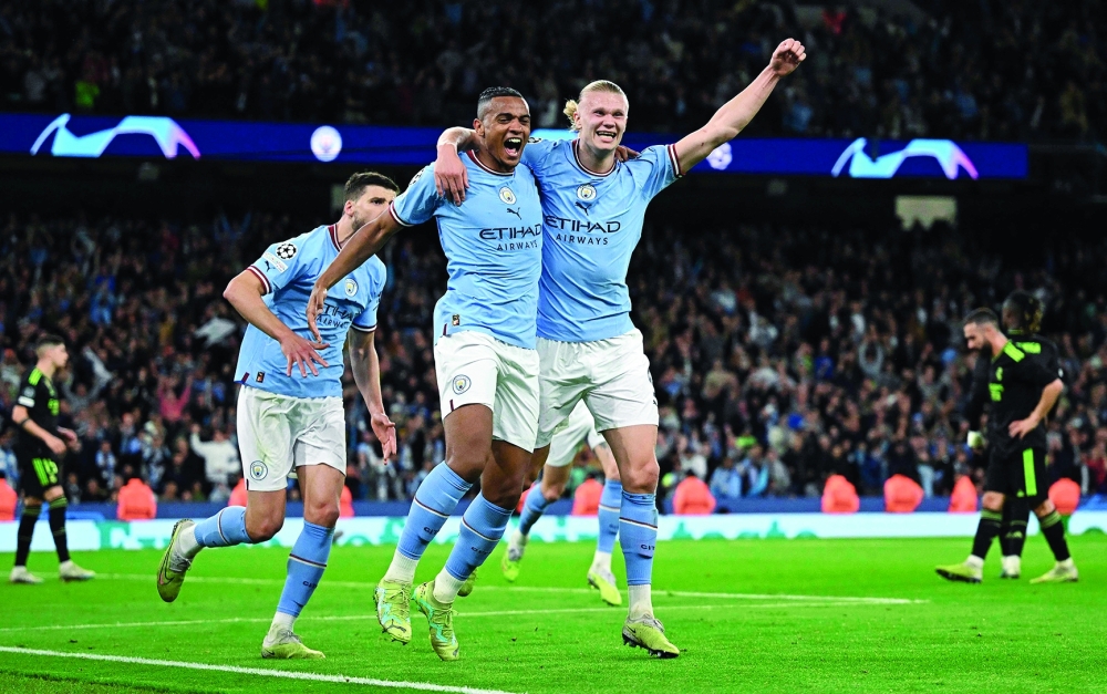 TOPSHOT - Manchester City's Swiss defender Manuel Akanji (L) celebrates scoring the team's third goal with Manchester City's Norwegian striker Erling Haaland during the UEFA Champions League second leg semi-final football match between Manchester City and Real Madrid at the Etihad Stadium in Manchester, north west England, on May 17, 2023. (Photo by Oli SCARFF / AFP)

