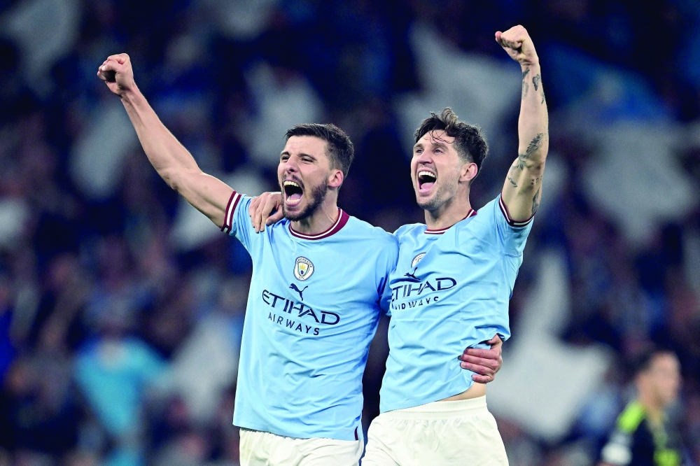 Manchester City's Portuguese defender Ruben Dias (L) and Manchester City's English defender John Stones celebrates after the UEFA Champions League second leg semi-final football match between Manchester City and Real Madrid at the Etihad Stadium in Manchester, north west England, on May 17, 2023. Manchester City won the match 4-0. (Photo by Paul ELLIS / AFP)

