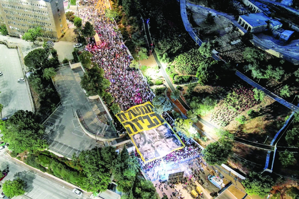 An aerial view shows Israeli protestors holding a sign which says in Hebrew "looting government" at a demonstration against Israeli PM Benjamin Netanyahu in Jerusalem. — Reuters 
