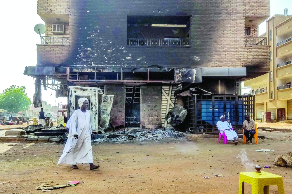 A man walks past a burnt out bank branch in southern Khartoum as fighting had calmed following ceasefire. — AFP 