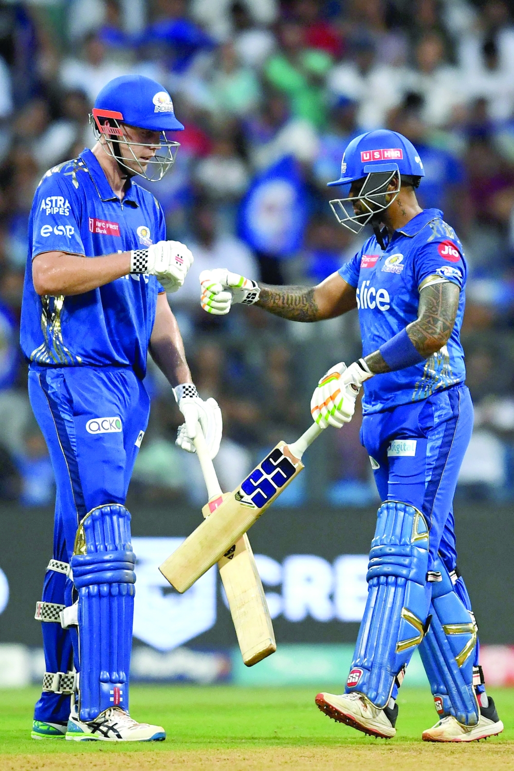 Mumbai Indians' Cameron Green (L) and Suryakumar Yadav bump their fists during the Indian Premier League (IPL) Twenty20 cricket match between Mumbai Indians and Sunrisers Hyderabad at the Wankhede Stadium in Mumbai on May 21, 2023.  (Photo by INDRANIL MUKHERJEE / AFP / )