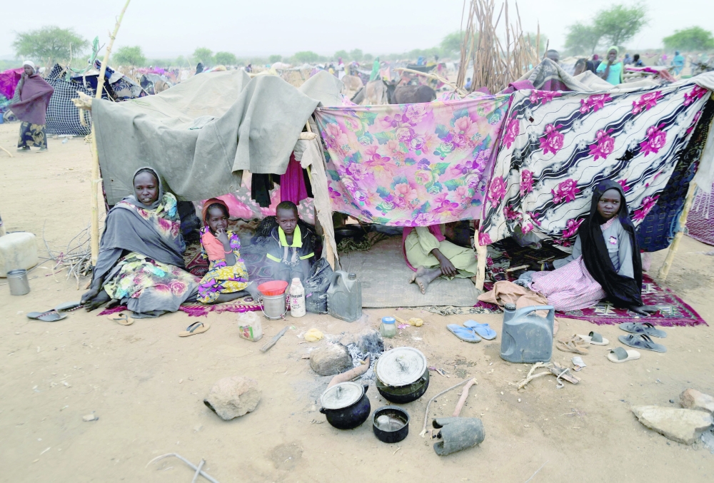 Sudanese refugees who have fled the violence in Sudan's Darfur region sit at their makeshift shelters near the border between Sudan and Chad in Koufroun, Chad. - Reuters