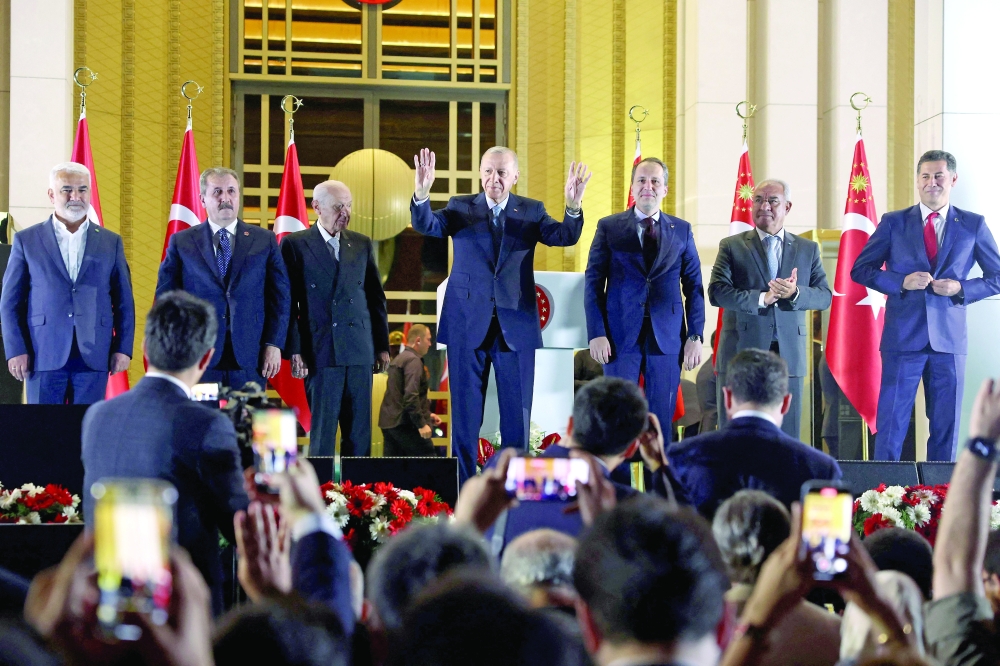 Turkish President Erdogan and his party's allies greet his supporters following his victory at the Presidential Palace in Ankara. — AFP 