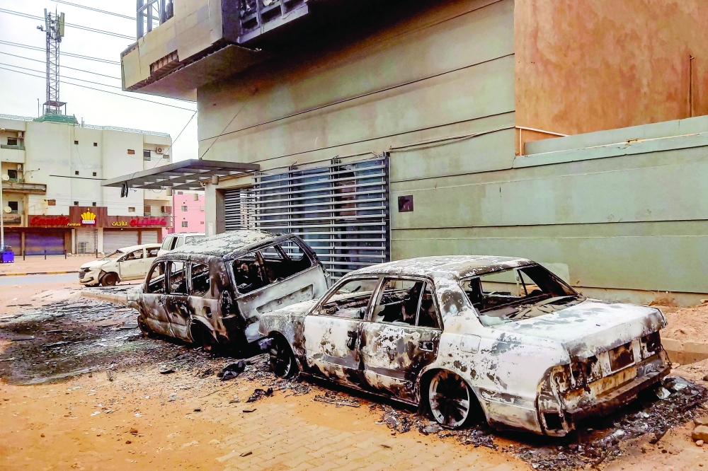 Destroyed vehicles are pictured outside the burnt-down headquarters of Sudan's Central Bureau of Statistics, in the south of Khartoum. — AFP 