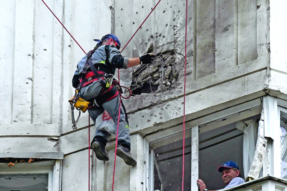 A specialist inspects the damaged facade of a multi-storey apartment building after a reported drone attack in Moscow. — AFP 