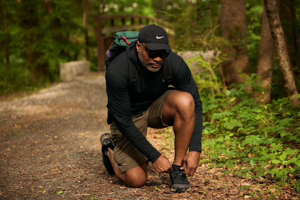 A hiker ties his shoes on a trail in Marietta, Ga., May 19, 2023. (Bee Trofort/The New York Times)
