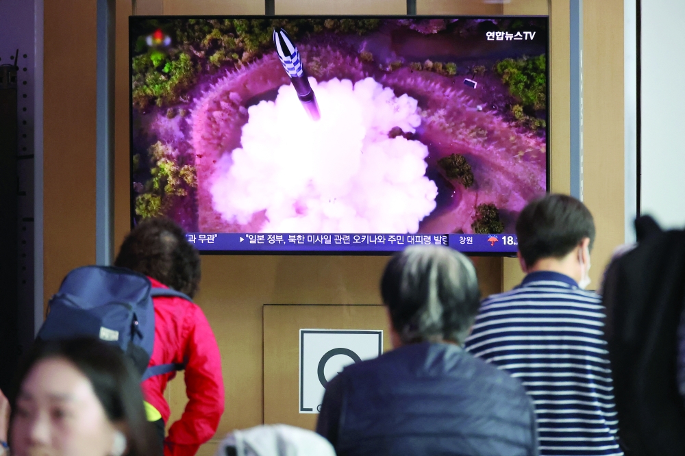 People watch a TV broadcasting a news report on North Korea firing what it called a space satellite toward the south, in Seoul. — Reuters 