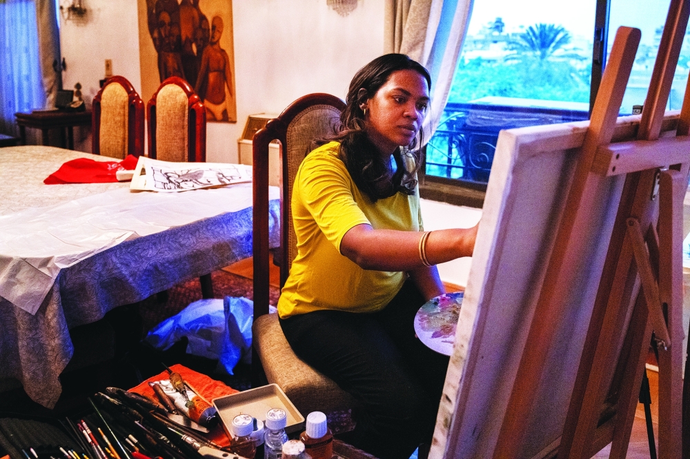 Dahlia Abdelilah Baasher, a Sudanese artist, paints at her new home in Cairo.
