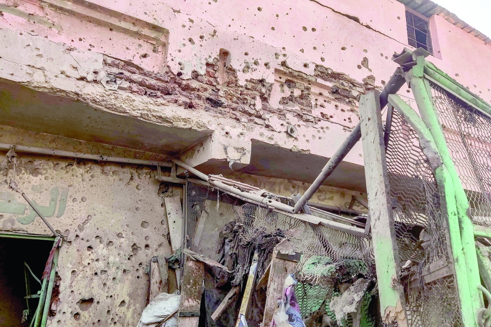 Bullet holes riddle the wall of a building at the Souk Sitta in the south of Khartoum. - AFP
