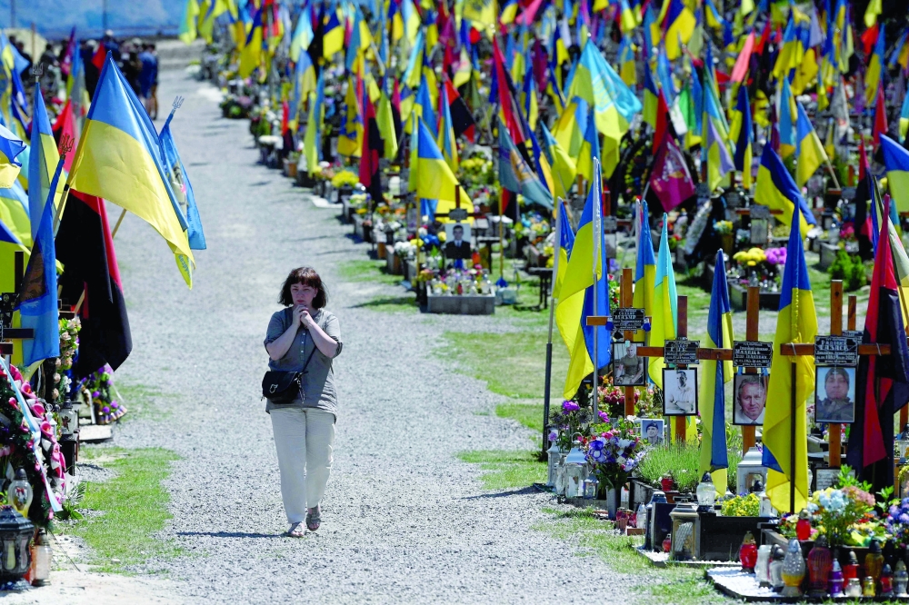 A woman walks among graves at the Lychakiv military cemetery in the western Ukrainian city of Lviv amid the Russian invasion of Ukraine. - AFP


