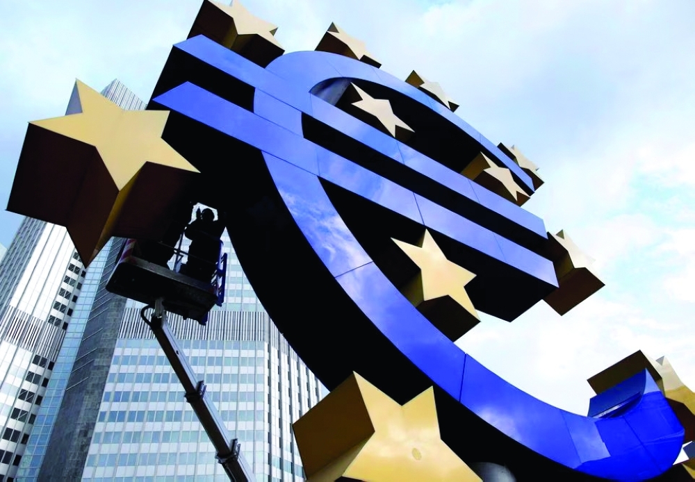 Workers maintain the huge Euro logo in front of the headquarters of the European Central Bank in Frankfurt. — Reuters