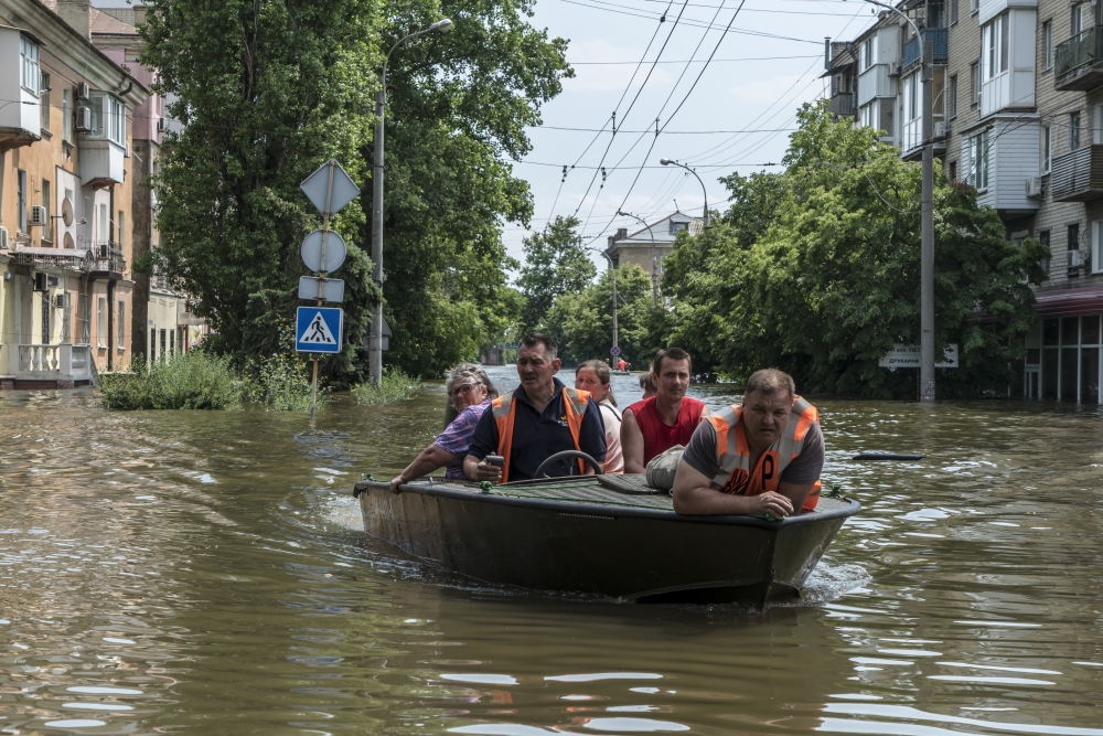 A rescue boat carries residents being evacuated from flooded areas in Kherson, Ukraine, June 8, 2023. (Brendan Hoffman/The New York Times)