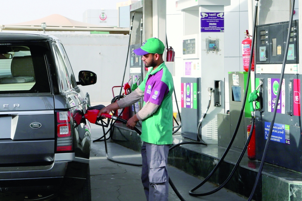A worker fills a vehicle with petrol at a gas station in Riyadh, Saudi Arabia. —  Reuters