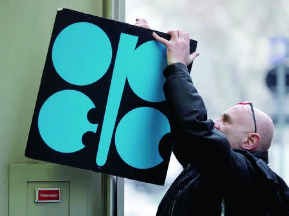 A man fixes a sign with Opec's logo next to its headquarters' entrance in Vienna, Austria. — Reuters