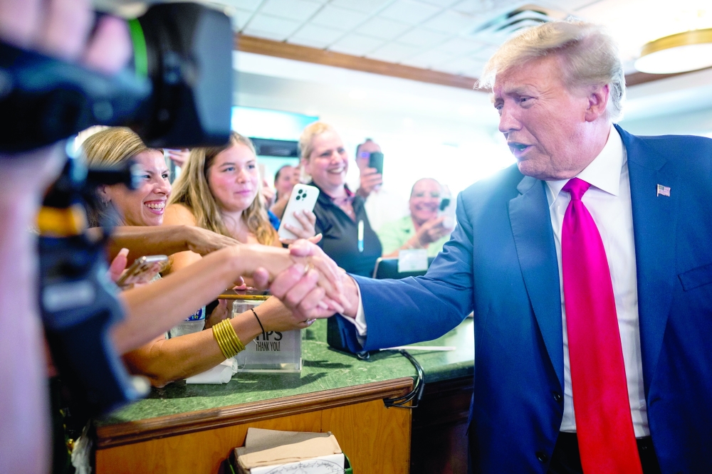 Former president Donald Trump greets people during a stop at the Versailles restaurant in the Little Havana neighbourhood in Miami.