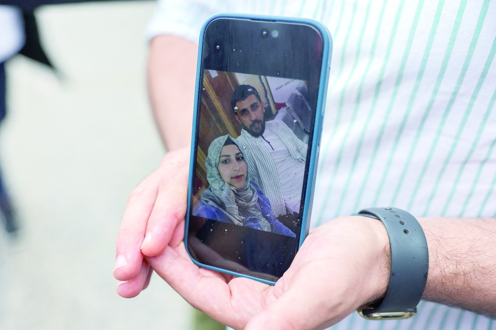 Syrian Kassam Abozeed, who says his wife Israa and brother-in-law were onboard a boat with migrants that capsized at open sea off Greece, demonstrates a photo of him and his wife, at the port of Kalamata, Greece. — Reuters